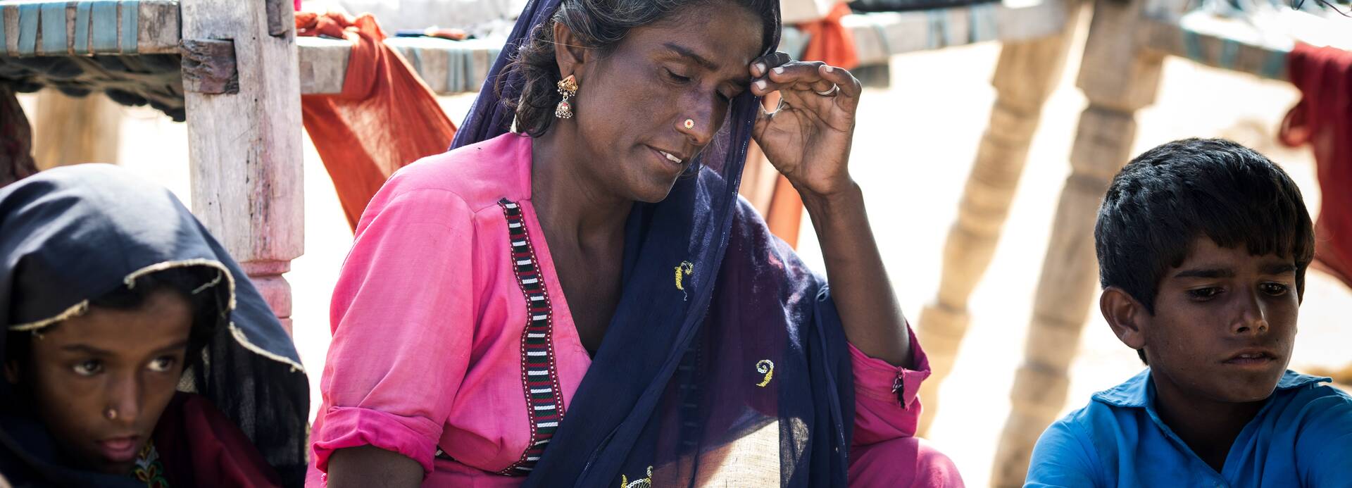 Seema aus Pakistan mit ihren beiden Kindern. Bei den Überschwemmungen haben sie ihr Zuhause verloren und sind nun der Hitze ausgesetzt.