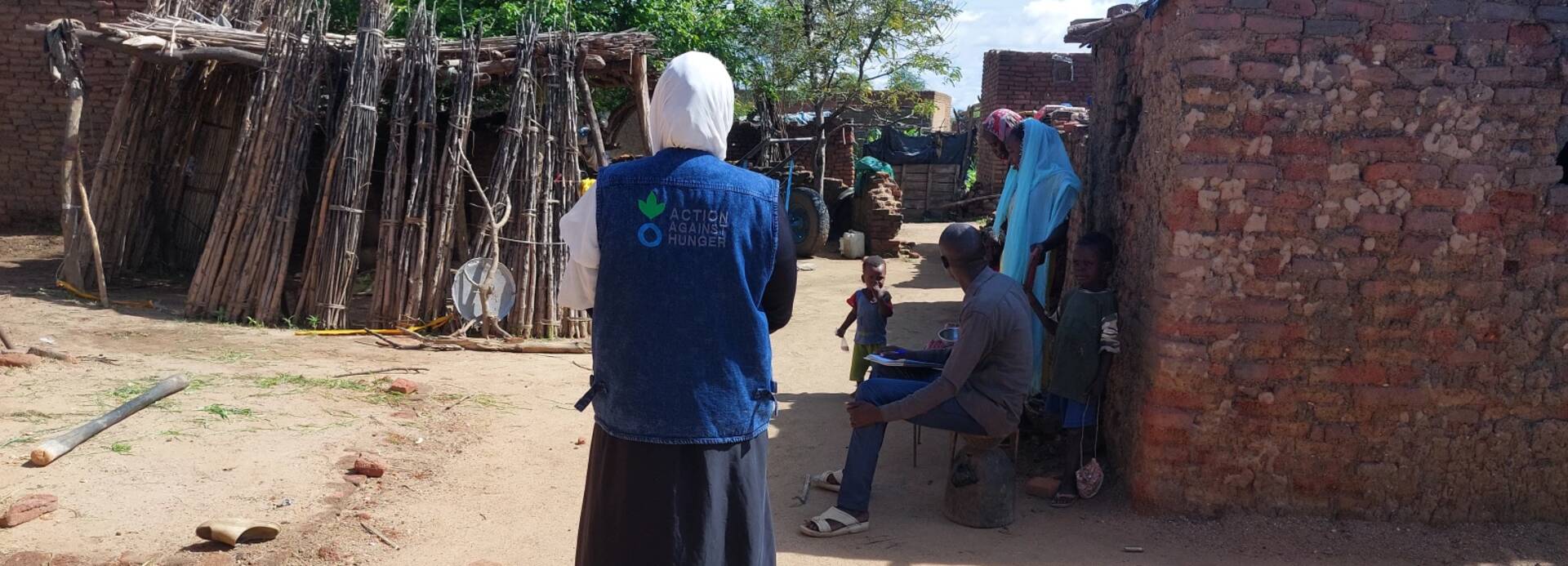 Eine Mitarbeiterin von Aktion gegen den Hunger läuft durch ein sudanesisches Dorf.