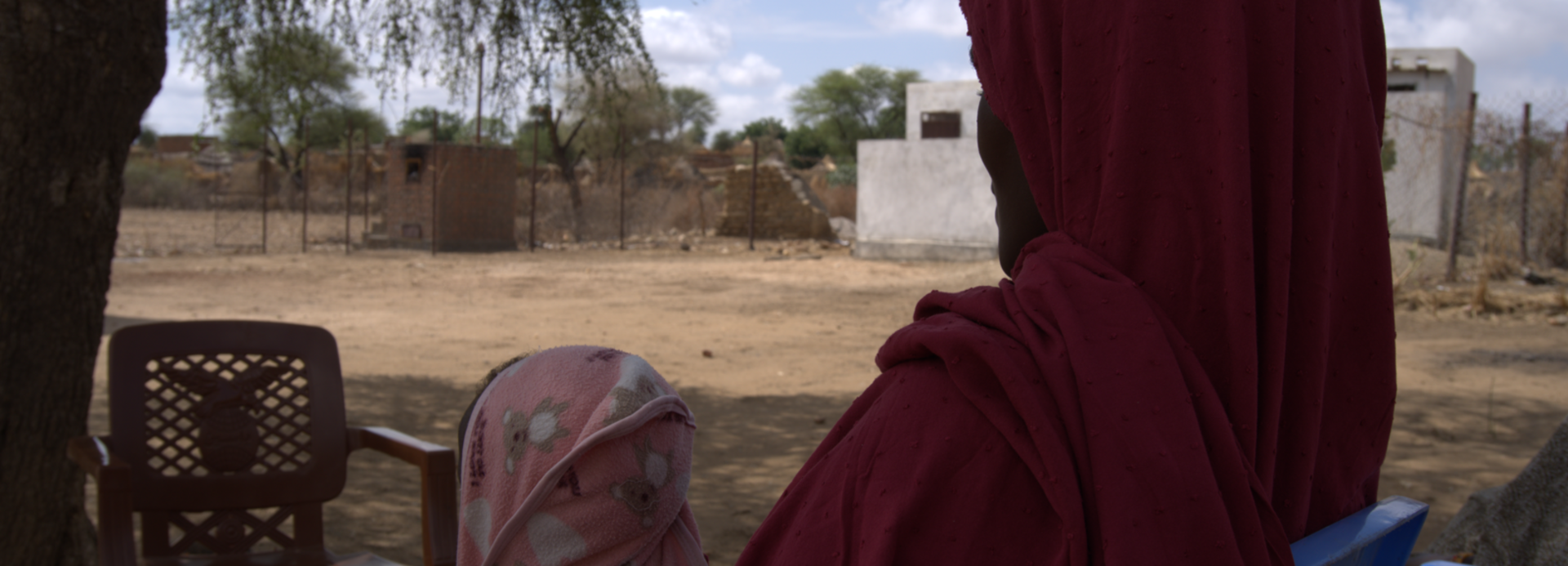 Eine Frau und ihr Kind seitlich/von hinten fotografiert im Sudan