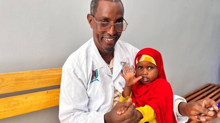 Dr. Hindiye mit einem kleinen Mädchen auf dem Arm