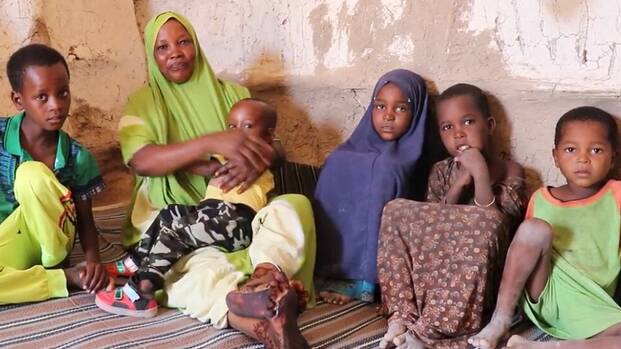 In Somalia sitzt eine Frau zusammen mit ihren Kindern in ihrem Haus.