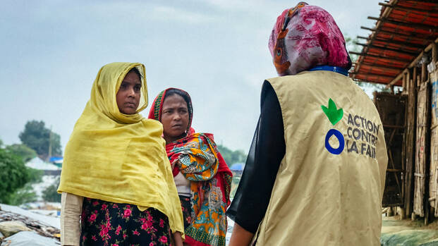Mitarbeiterin von Aktion gegen den Hunger und zwei Frauen in Bangladesch