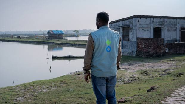 Ein Mitarbeiter von Aktion gegen den Hunger vor überflutetem Gebiet in Bangladesch